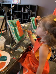 girl painting canvas at Pinot's Palette
