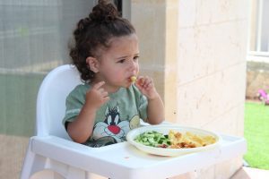 Little girl eating on her own