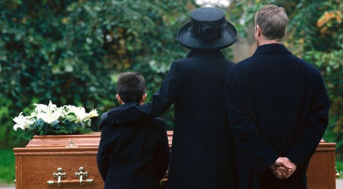 pic of family standing by a casket