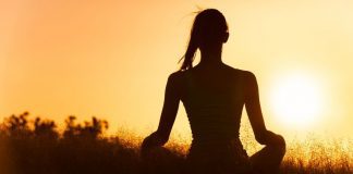 pic of a woman meditating at sunrise