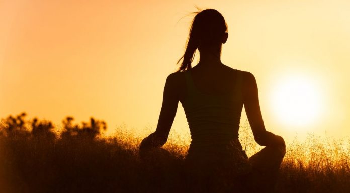 pic of a woman meditating at sunrise
