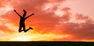 happy woman jumping at sunset