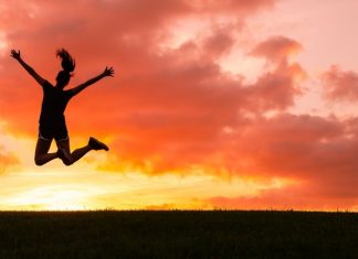happy woman jumping at sunset