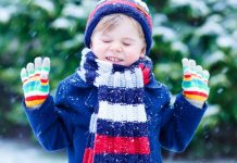 boy in winter layers outside in the snow