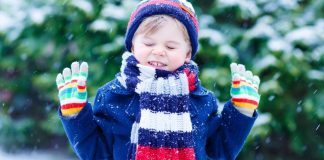boy in winter layers outside in the snow