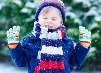boy in winter layers outside in the snow