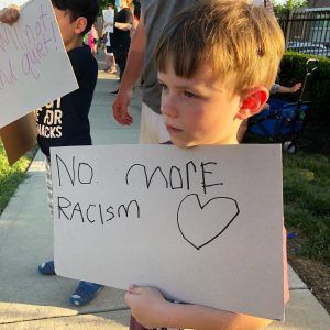 boy with no more racism sign