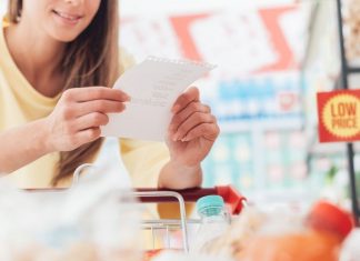 woman looking at a grocery list while at the store