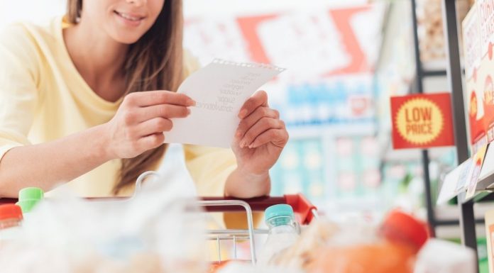 woman looking at a grocery list while at the store