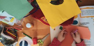 a child's hands doing craft with construction paper