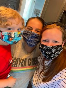 two moms and little boy wearing masks