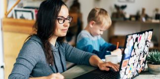 mom working from home on computer with child nearby
