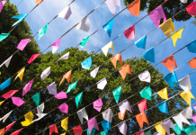 June Bucket List for Kansas City Families banner flags against sky and trees