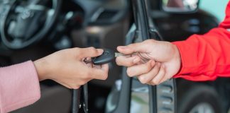 one person giving car keys to another, only hands pictured