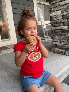 little girl eating fall donut