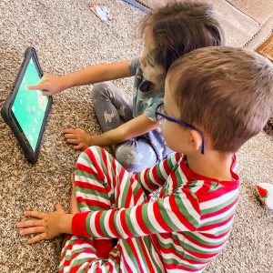 two kids playing on an iPad