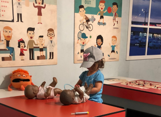 girl checking on doll babies at KidScape doctor exhibit