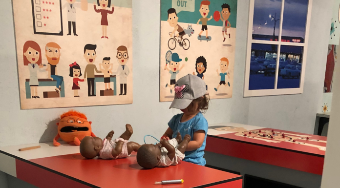girl checking on doll babies at KidScape doctor exhibit