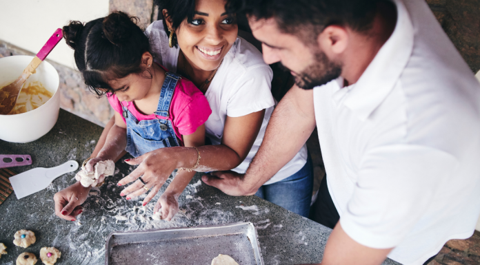 mom and dad making cookies with little girl