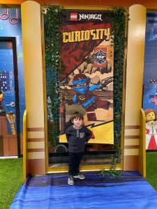 child in front of Ninjago Curiosity poster