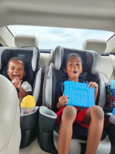 Smiling excited boys in backseat on road trip