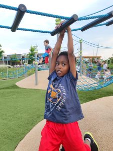 Young boy crossing obstacle ropes
