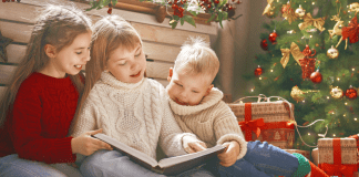 kids reading books under Christmas tree