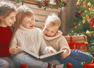 kids reading books under Christmas tree