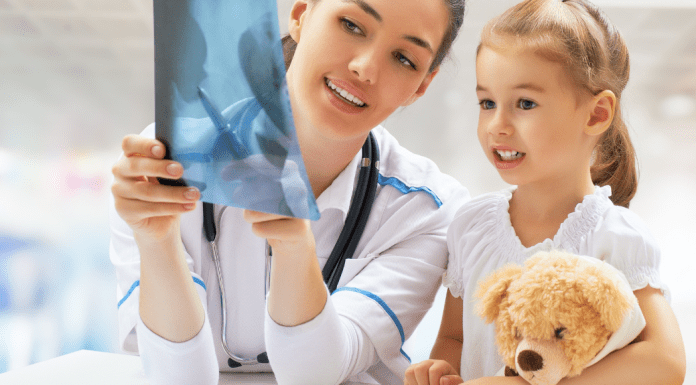 doctor looking at x-ray with child at urgent care